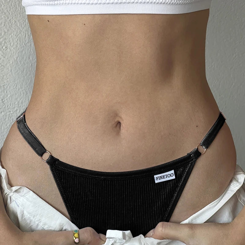 Person wearing a black thong with 'FINE優' branding against a neutral background