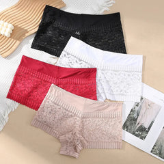 Four pairs of lace underwear in black, red, white, and beige on a textured surface.