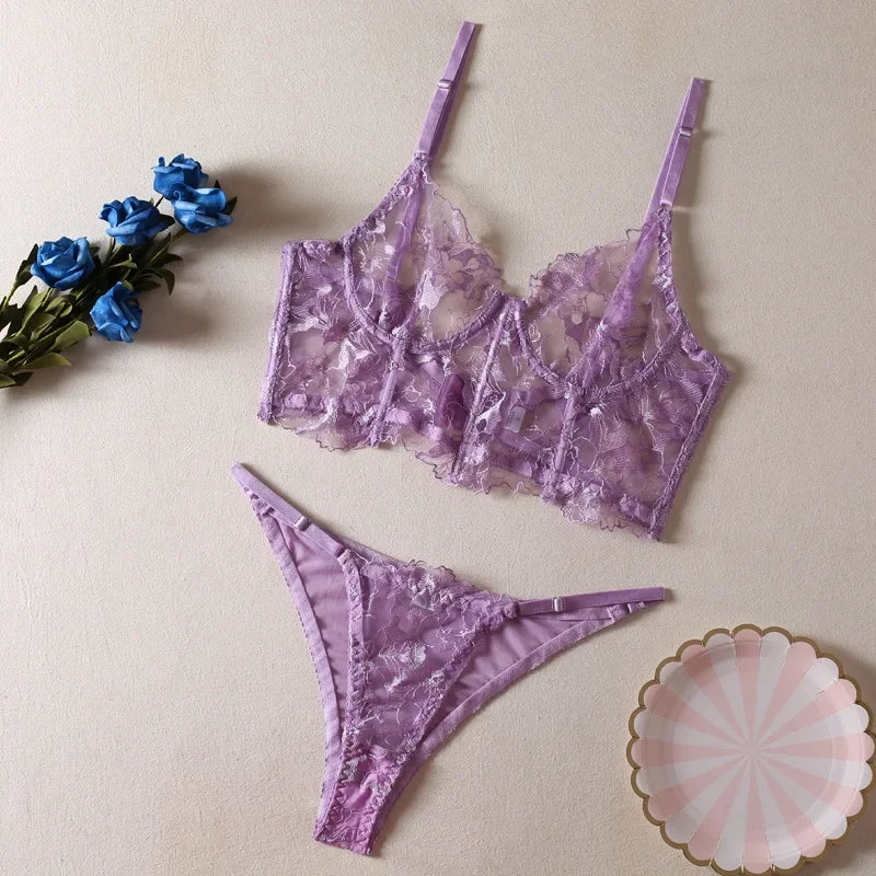 Purple lace lingerie set with a decorative plate and flowers on a beige background