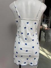 White dress with blue heart patterns on a mannequin against a neutral background