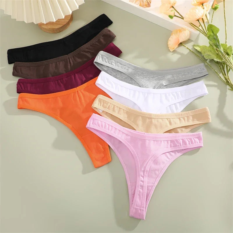Set of colorful women's underwear on a light surface with flowers in the background