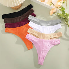 Set of colorful women's underwear on a light surface with flowers in the background