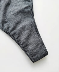 Close-up of gray knit fabric and stitched edging on a thong garment.