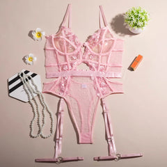 Pink lace lingerie set on a beige background with decorative items.