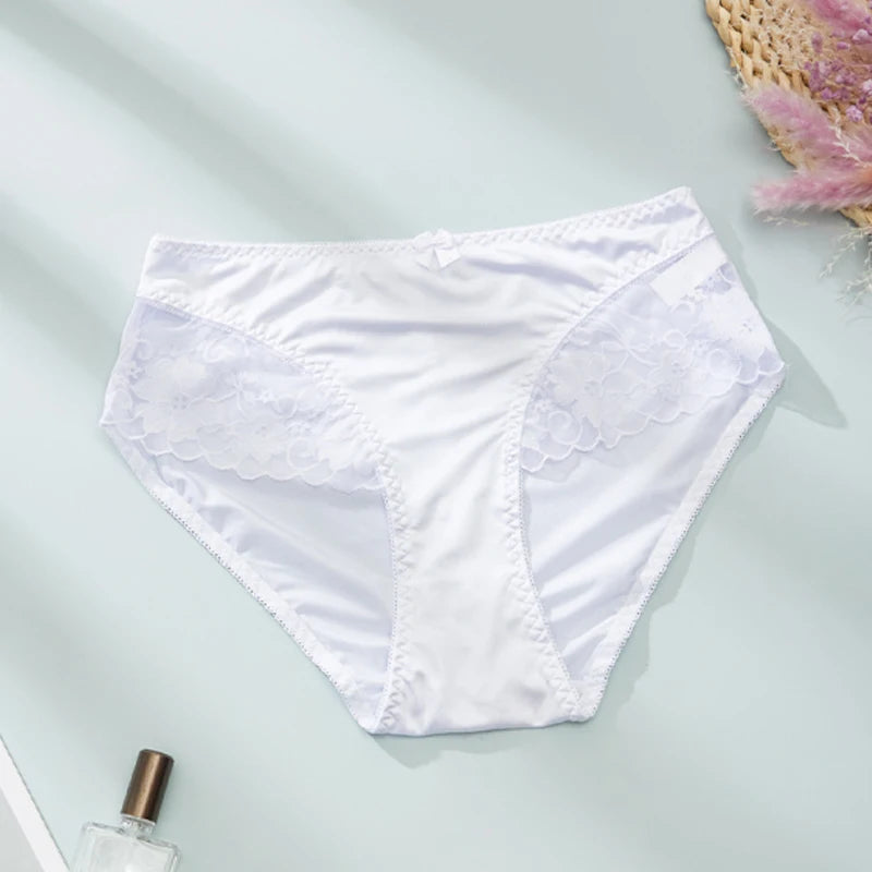 White underwear on a light gray surface with a small plant and bottle in the background