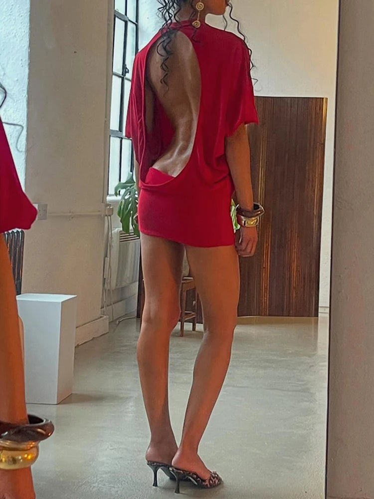 Person wearing a red outfit standing in a room with a mirror.