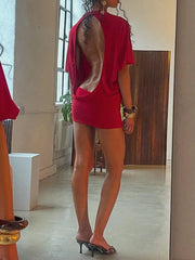 Person wearing a red outfit standing in a room with a mirror.
