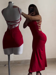 Woman in a red dress standing next to a mannequin wearing a similar dress.