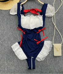 Navy blue swimsuit with red and white details on a gray surface.