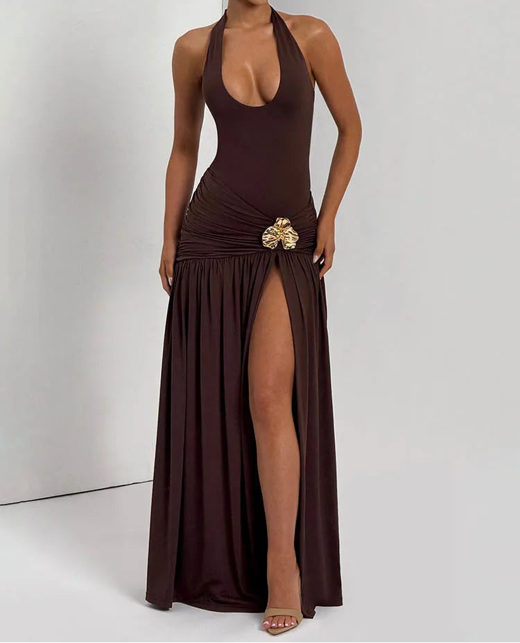 Woman wearing a brown halter neck dress with a gold embellishment on a white background