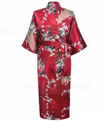 Red satin robe with floral patterns on a white background