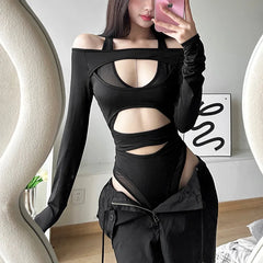 Person wearing a black outfit with cut-out design in a room.