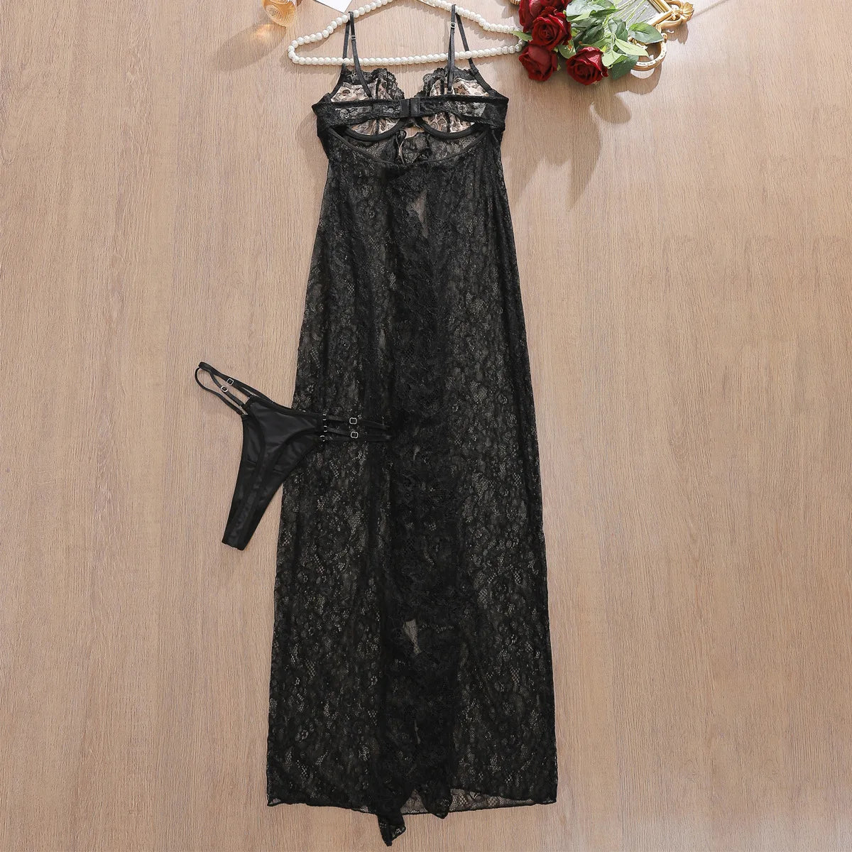 Black lace lingerie set on a wooden surface with a neutral background