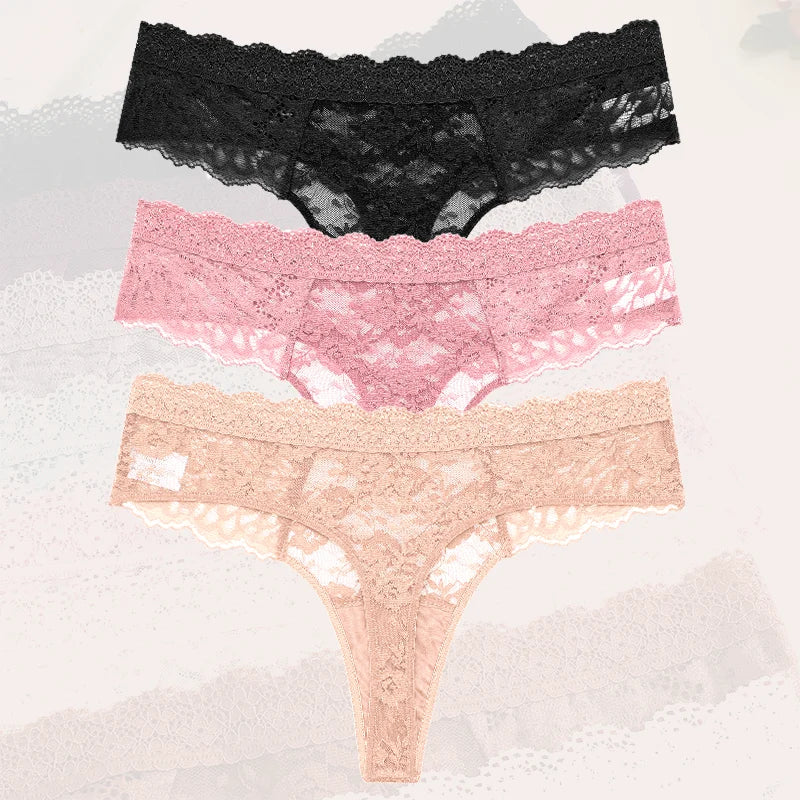 Three pairs of lace underwear in black, pink, and beige on a textured gray background.