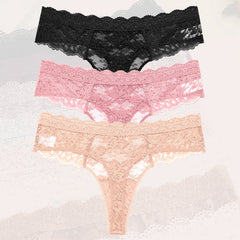 Three pairs of lace underwear in black, pink, and beige on a textured gray background.