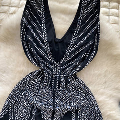 Black and white patterned dress on a textured beige surface