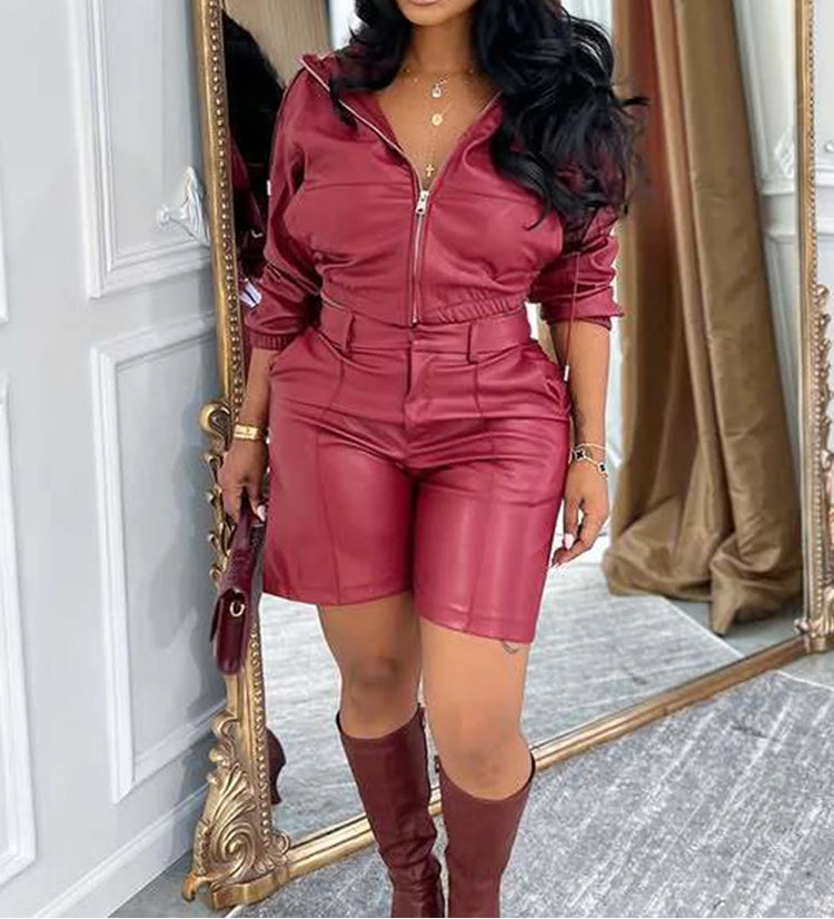 Woman in a maroon outfit standing in front of a mirror.