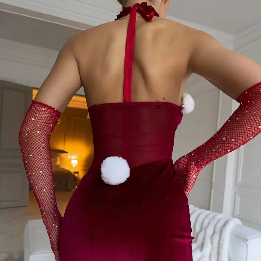 Person wearing a red dress with white polka dots and red fishnet gloves indoors.