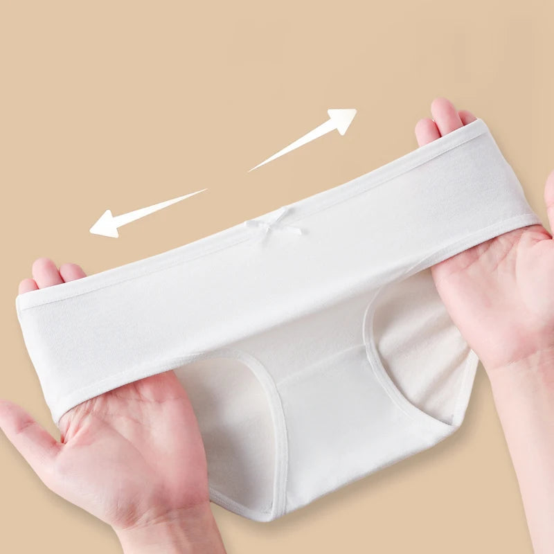 White underwear held by hands on a beige background