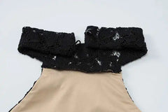 Black lace collar on a beige garment against a white background