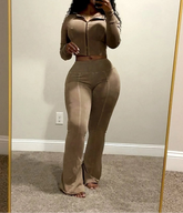 Person wearing a beige jumpsuit standing in front of a mirror.