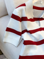 White sweater with red stripes on a light-colored couch