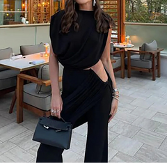 Woman in a black outfit standing in an outdoor cafe setting