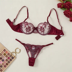 Red lace lingerie set with roses and makeup palette on a light background