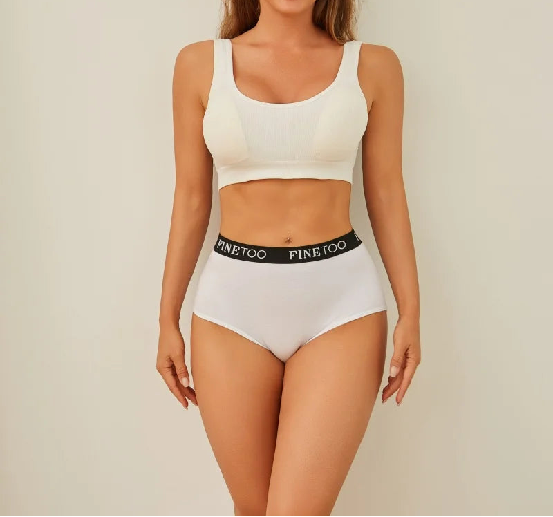 Woman wearing a white sports bra and high-waisted shorts with 'FINEtoo' branding on a beige background