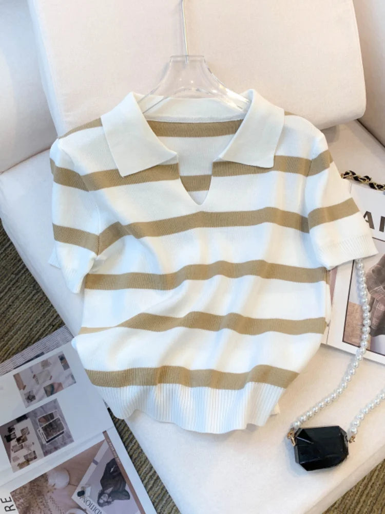 White and beige striped shirt on a hanger with a magazine underneath