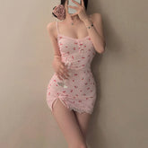 Person wearing a pink lace nightgown holding a glass against a plain background