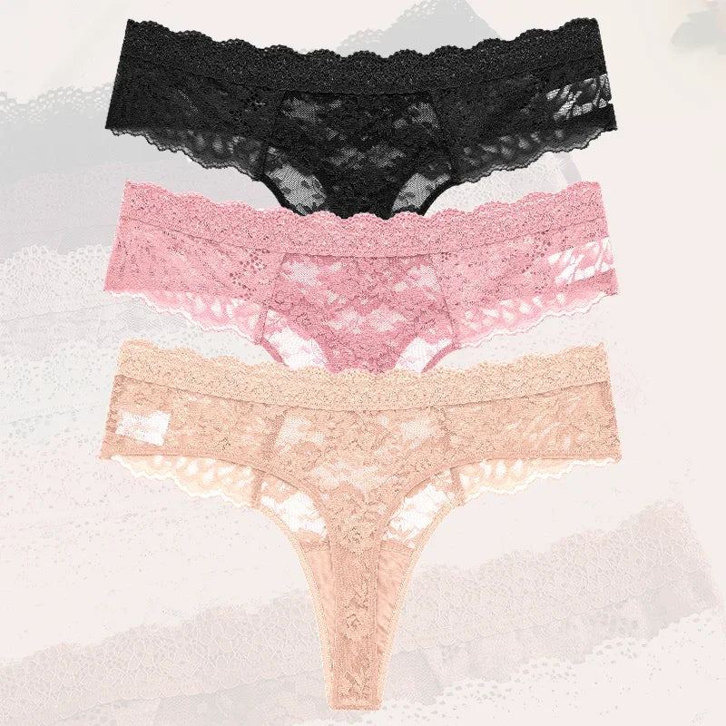 Three pairs of lace-trimmed panties in black, pink, and beige on a textured white background.