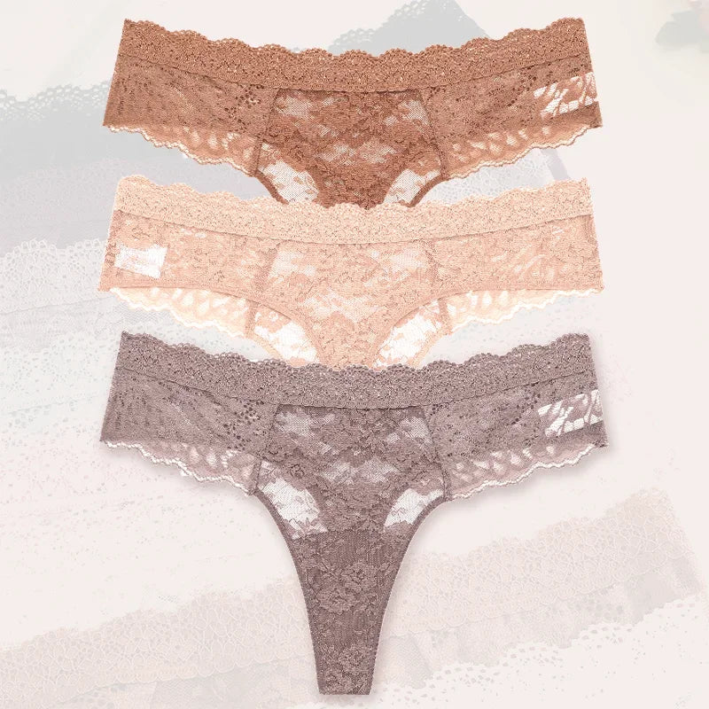 Three pairs of lace underwear in different colors on a textured surface.