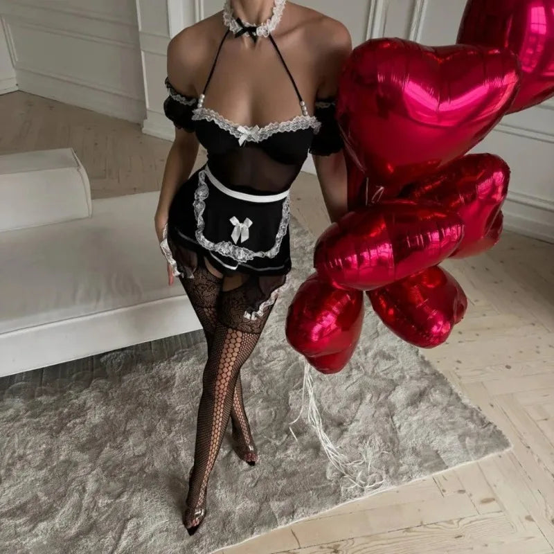 Person in black lingerie and stockings holding red heart-shaped balloons indoors.