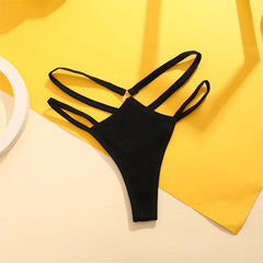 Black bikini bottom on a yellow fabric background