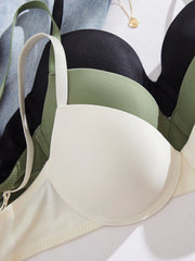 Three bras in black, green, and beige on a light gray background