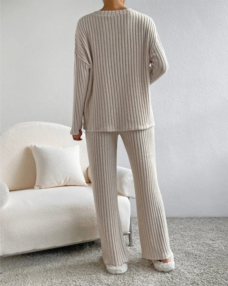 Person wearing a beige ribbed lounge set in a living room.