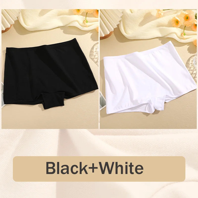 Black and white boxer briefs on a beige surface with floral decorations.