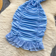 Blue ruffled pet dress on a fur surface