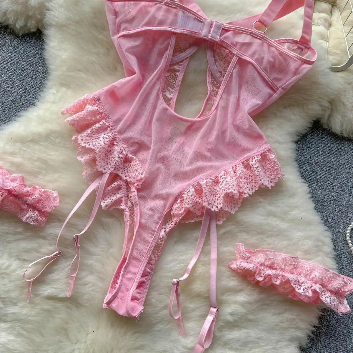 Pink lace lingerie set on a fluffy white surface