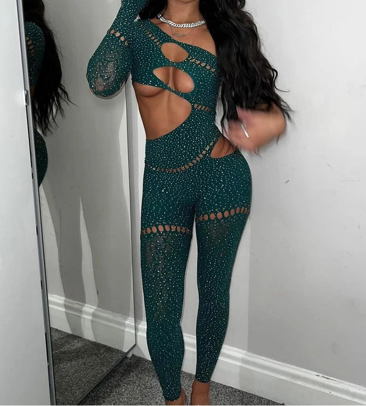 Woman wearing a green crochet outfit standing in front of a mirror.