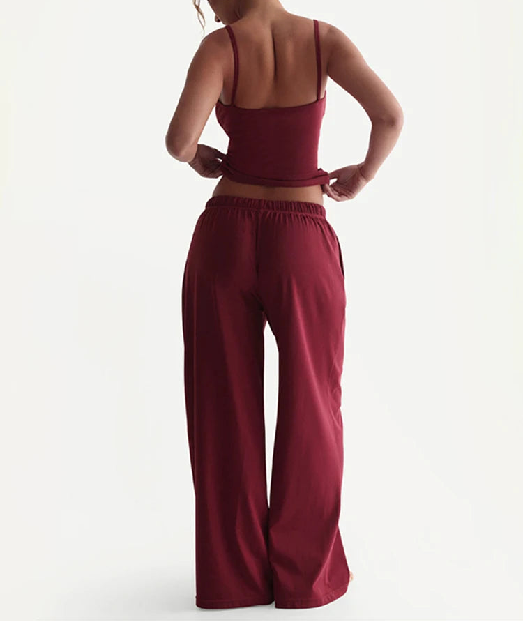 Person wearing a burgundy outfit with wide-leg pants on a white background