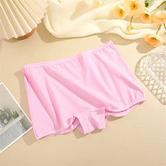 Pink underwear on a beige surface with flowers and a magazine in the background