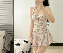 Woman taking a mirror selfie wearing a floral dress in a room.