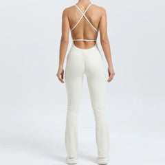 Person wearing a white outfit with a strappy top on a plain background