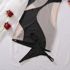 Black lingerie set with sheer overlay on a white background with red roses.