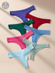 Set of seven colorful ribbed thongs on a beige background