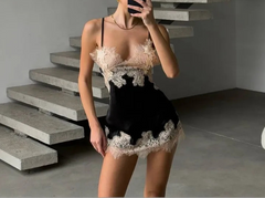 Person taking a mirror selfie wearing a black and beige lace dress in a modern interior setting.