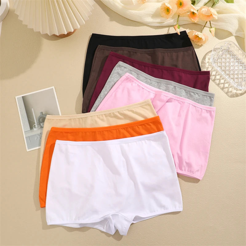 Set of colorful women's underwear on a beige surface with decorative elements.