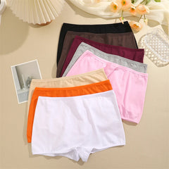 Set of colorful women's underwear on a beige surface with decorative elements.